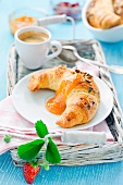 A croissant with apricot jam and coffee for breakfast