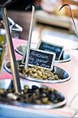 Various types of preserved olives at a market