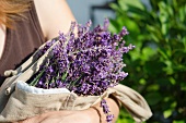 A woman holding a linen bag with lavender flowers