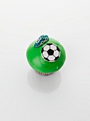 A green cupcake decorated with football motifs
