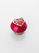 A cupcake decorated with a mouse couple and a heart