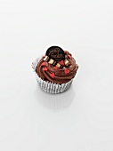 A cupcake decorated with chocolate cream and hearts