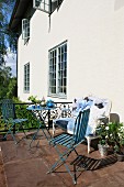 Teatime auf sonniger Terrasse mit neu gepolstertem Antiksofa und leichten, blauen Gartenmöbeln im Vintage-Look