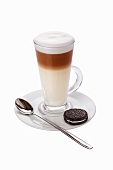 A caffe latte with a chocolate biscuit