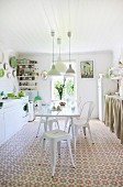 White dining set in sunny kitchen-dining room with cheerful floral flooring and green accents