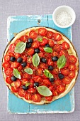 A ham, cheese, cherry tomatoes, olives and basil tart