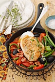 Chicken breast with tomatoes, green beans, olives and bacon