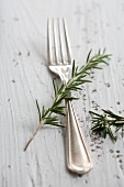 A silver fork with rosemary