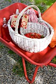 A wheelbarrow with a basket, redcurrants and redcurrant juice