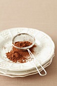 Cocoa powder in a sieve on a plate