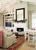 Interior with traditional-style sofa set in front of fireplace & white-painted dining set