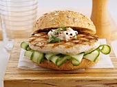 A chicken burger with aioli and cucumber