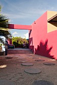 Innenhof des Hotelito mit runden Pflastersteinen und rosa Wänden