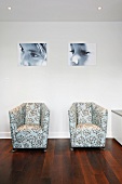 Modern armchairs with patterned upholstery fabric in front of a wall with portraits of children
