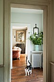 View of black and white cat in connecting room leading to country-house-style living room