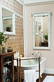 Nostalgisches Bad mit freistehender Badewanne und verschiedenen Wandspiegeln an unterschiedlich gestalteten Wänden