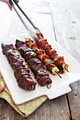 Placing Grilled Beef and Vegetable Kabobs on a Platter