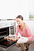 Woman holding a baking tray with burnt cupcakes