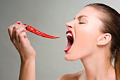 Frau will in eine rote Chilischote beissen