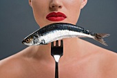 Woman holding a fish on a fork