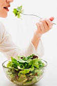 Frau isst Blattsalat