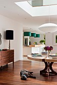 Offener Wohnraum mit Pendelleuchte im Japanstil, eleganter Tischlampe und grünen Hängeleuchten über Küchentheke