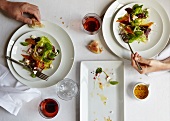 Zwei Portionen von Wintersalat mit gebratenen Möhren auf einem Tisch