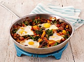 Fried eggs with broccoli and pepper in a pan