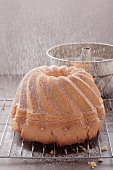 A ring cake being dusted with icing sugar