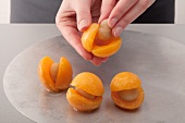 A hand filling apricots with marzipan