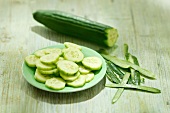 A cucumber, partially peeled and sliced