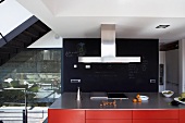 Red kitchen island in front of black slate wall panel