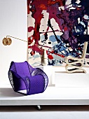 Designer chairs and lamp in front of tapestry