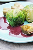 Jakobsmuscheln in blanchiertem Kopfsalat mit Artischocken und Zwiebel-Rotwein-Sauce