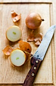 Onions, whole and halved, on a chopping board