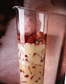 A layered dessert with vanilla cream, strawberries and candy floss