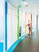 Curved wall with accents of various colours in corridor of contemporary office building
