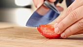 A tomato being chopped (close-up)