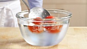 Blanched tomatoes being quenched in iced water
