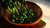 Frisch geerntete Oliven in eine Tonschüssel umfüllen