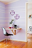 Small purple dining area with a simple folding table and black designer chair