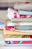 Stacked offcuts of various rose-patterned fabrics