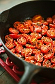 Halved Cherry Tomatoes Cooked with Salt, Pepper and Rosemary in a Skillet