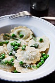 Raviolis with Peas and Parmesan Cheese in a White Bowl
