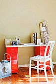 Writing surface on red metal containers on beige wall in sunny room