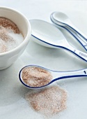 Cinnamon sugar in a bowl and on a spoon with a set of measuring spoons
