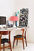 60s table lamp and photo collage on desk; retro chairs with leather seat cushions