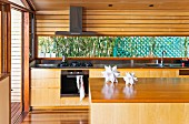 Island counter in front of kitchen counter with solid wood base units in residential house