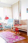 Bright nursery with cot, pale blue cantilever chair and red rocking moose