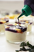 Mango pudding being drizzled with cassis